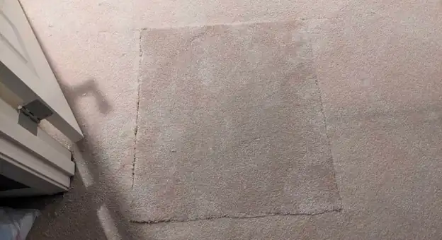 A previous amateur patch where the replacement piece does not match the surrounding carpet