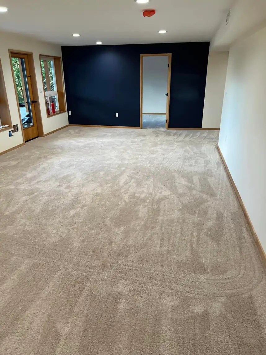 A finished room with fresh, flat carpet against a navy accent wall