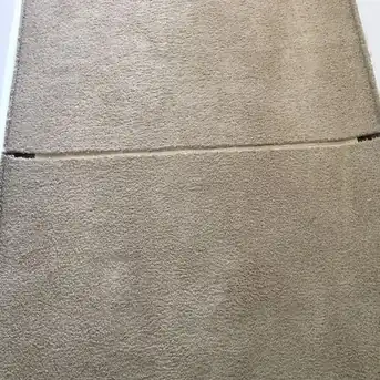 A hallway carpet visibly wrinkled before stretching begins