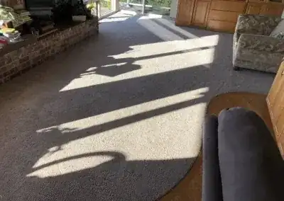 The same living room after stretching, carpet flat to the hardwood transition