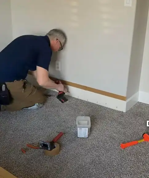 Subfloor being secured with screws while the carpet is folded back